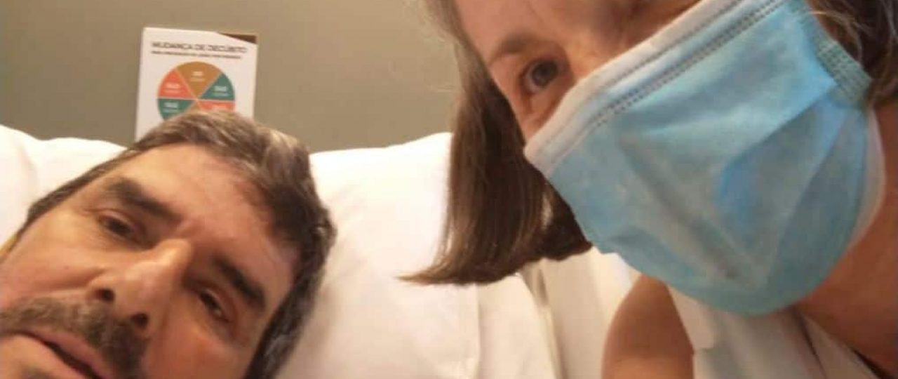 Photo of my dad recovering from Covid-19 at the hospital with my mom wearing a mask by his side